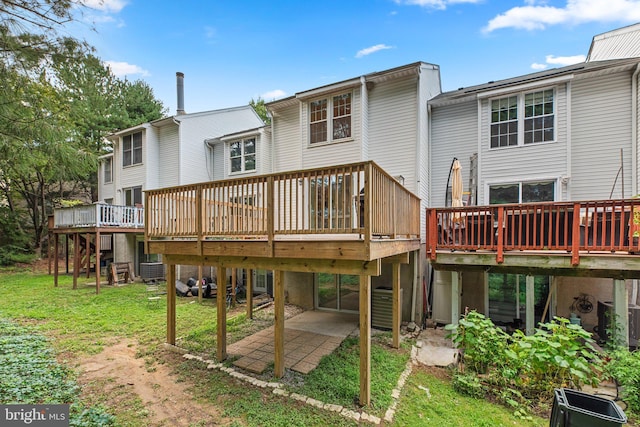 rear view of house with a patio area, a deck, and a lawn