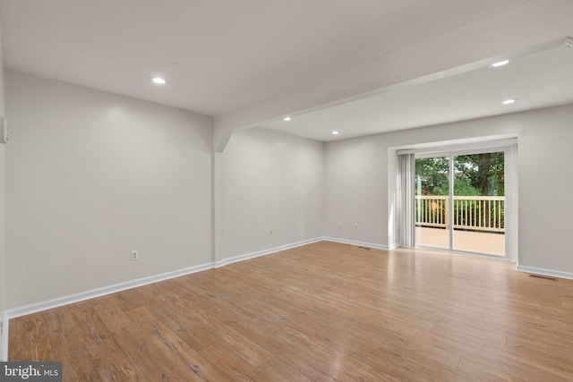 empty room with recessed lighting, wood-type flooring, and baseboards