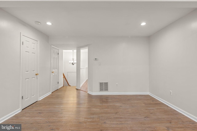 empty room with baseboards, wood finished floors, visible vents, and recessed lighting