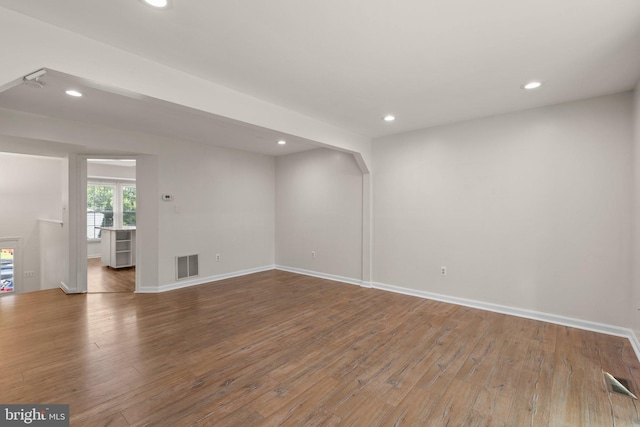 empty room with hardwood / wood-style flooring, visible vents, and recessed lighting