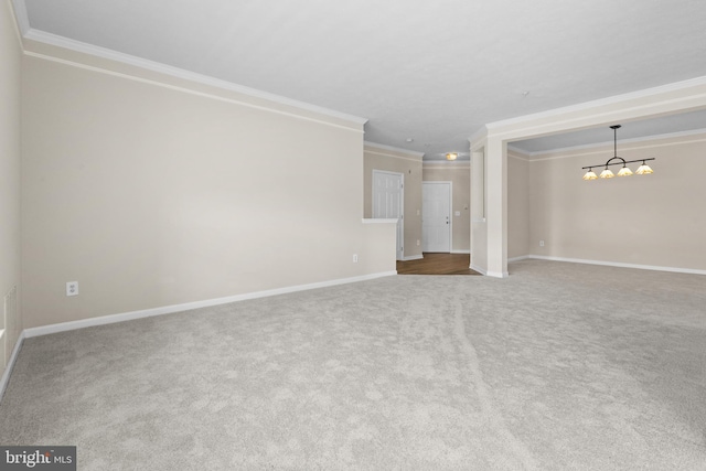 unfurnished living room featuring carpet floors, baseboards, a chandelier, and ornamental molding