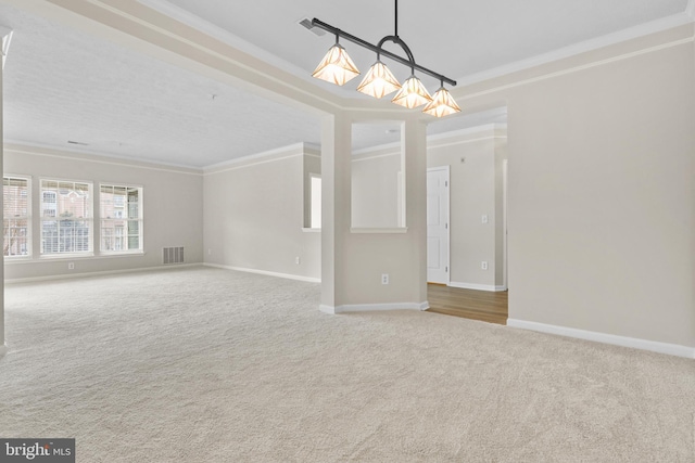 carpeted empty room featuring ornamental molding, visible vents, and baseboards