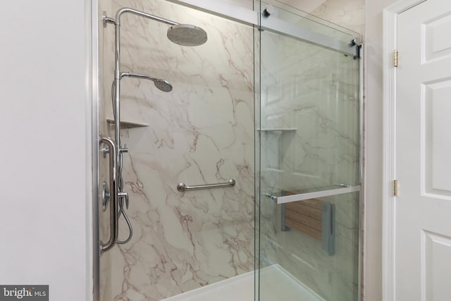 bathroom featuring a marble finish shower