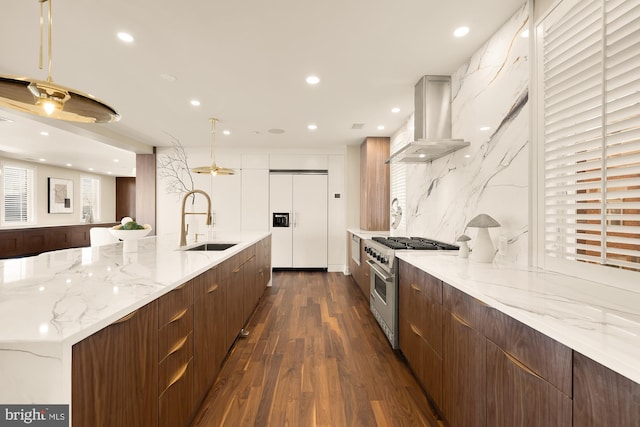 kitchen featuring premium appliances, modern cabinets, island exhaust hood, a large island with sink, and a sink