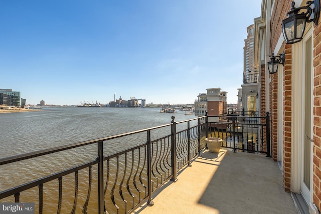 balcony featuring a water view and a city view