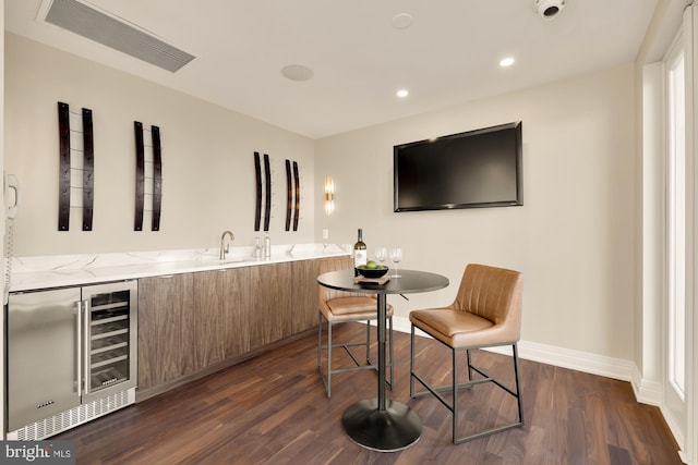 bar with beverage cooler, baseboards, visible vents, dark wood-type flooring, and recessed lighting