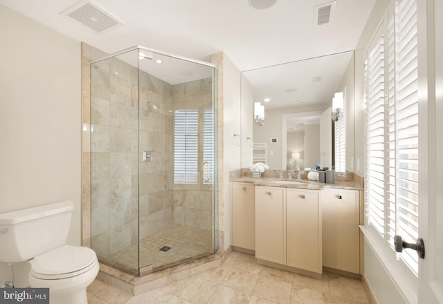 bathroom featuring toilet, a stall shower, and visible vents