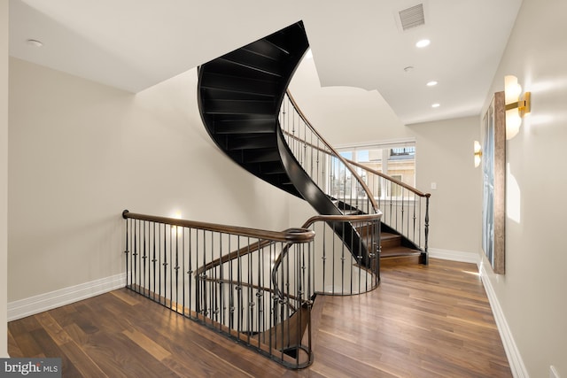 stairway featuring recessed lighting, visible vents, baseboards, and wood finished floors