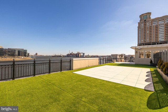 view of yard featuring a city view, fence, and a patio