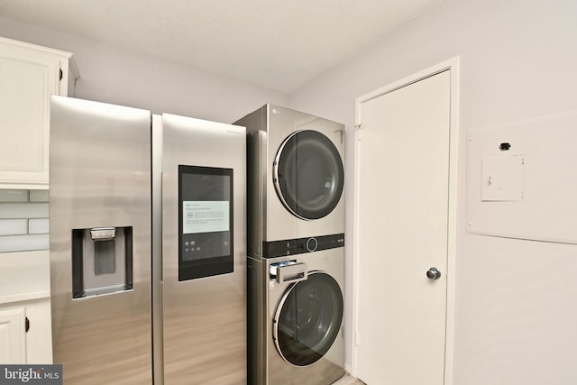 laundry room featuring stacked washer / dryer and laundry area