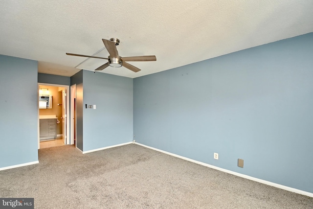 unfurnished bedroom featuring carpet, ensuite bathroom, ceiling fan, a textured ceiling, and baseboards