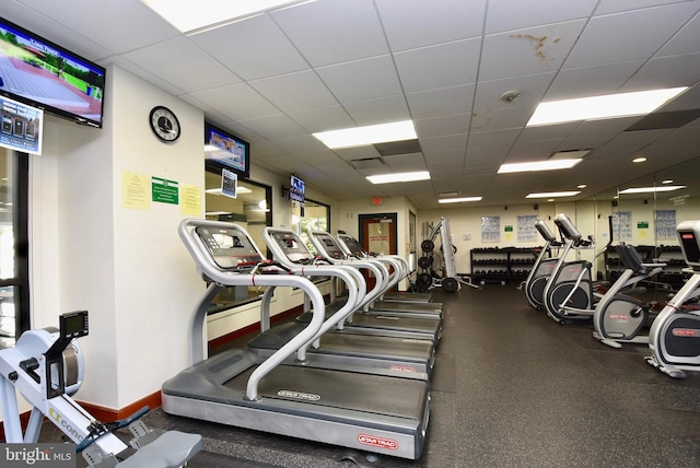 workout area with a drop ceiling and baseboards