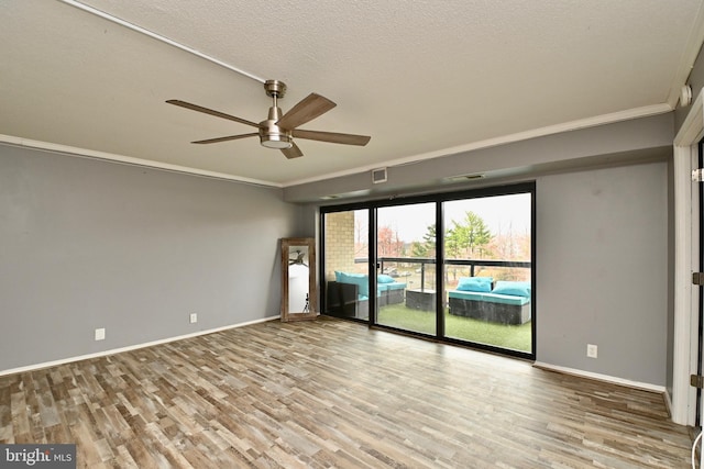 unfurnished room with baseboards, visible vents, crown molding, and wood finished floors