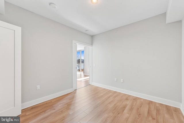 empty room with baseboards and light wood finished floors