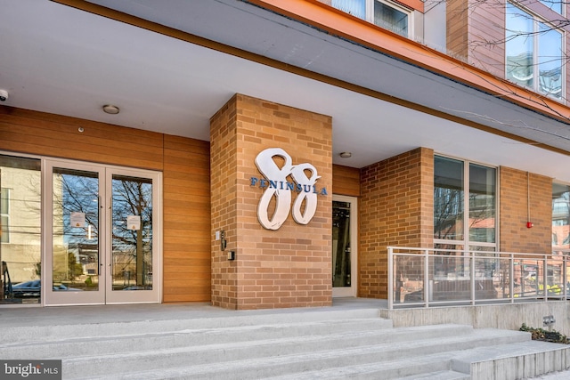 entrance to property featuring french doors and brick siding