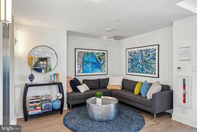 living area with baseboards and wood finished floors