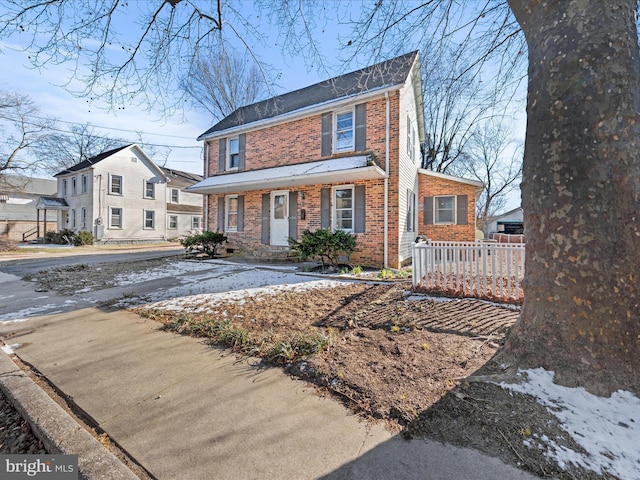 view of front facade with brick siding and fence