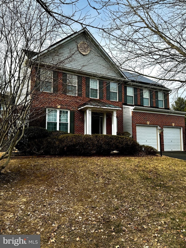 view of front of property featuring a garage, aphalt driveway, and brick siding