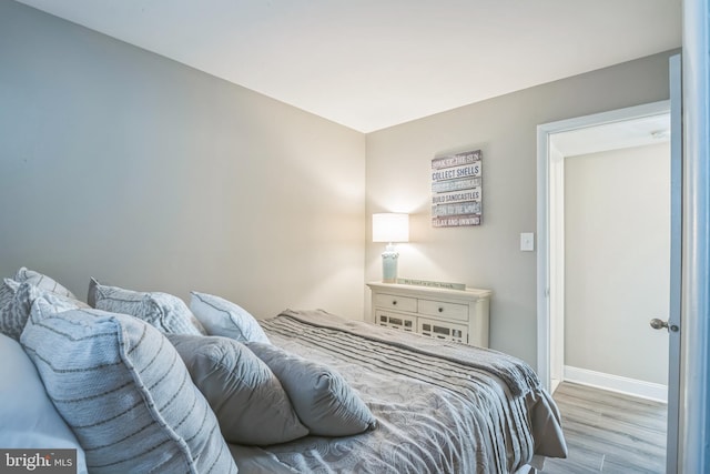 bedroom featuring light wood-type flooring and baseboards