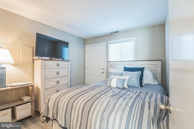 bedroom featuring wood finished floors and visible vents