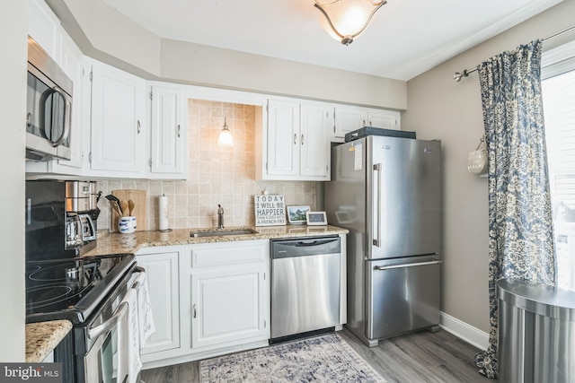 kitchen featuring stainless steel appliances, white cabinetry, and a sink