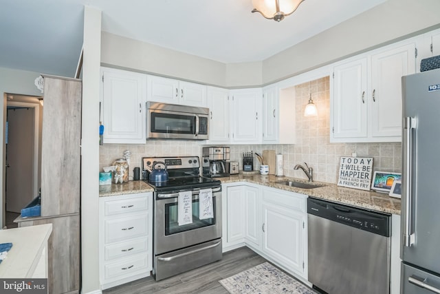 kitchen with white cabinetry, appliances with stainless steel finishes, decorative backsplash, and a sink