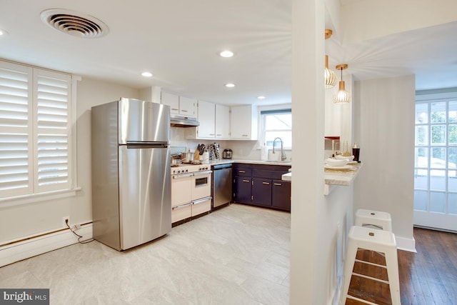 kitchen with stainless steel appliances, light countertops, visible vents, and plenty of natural light