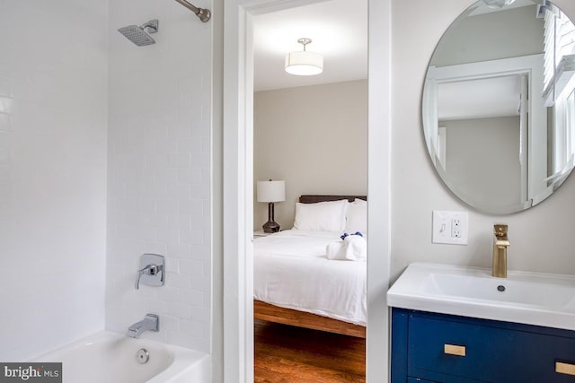 ensuite bathroom with  shower combination, vanity, ensuite bath, and wood finished floors