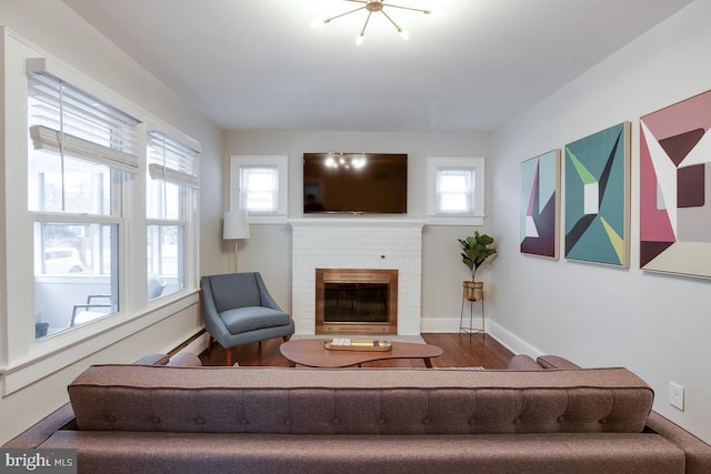 living area with a fireplace, baseboards, and wood finished floors