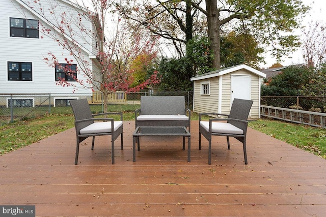 wooden deck with an outdoor hangout area, a shed, an outdoor structure, and a fenced backyard