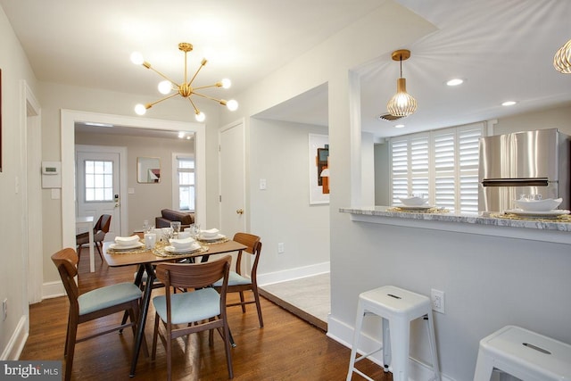 dining area with baseboards, a chandelier, dark wood-type flooring, and recessed lighting