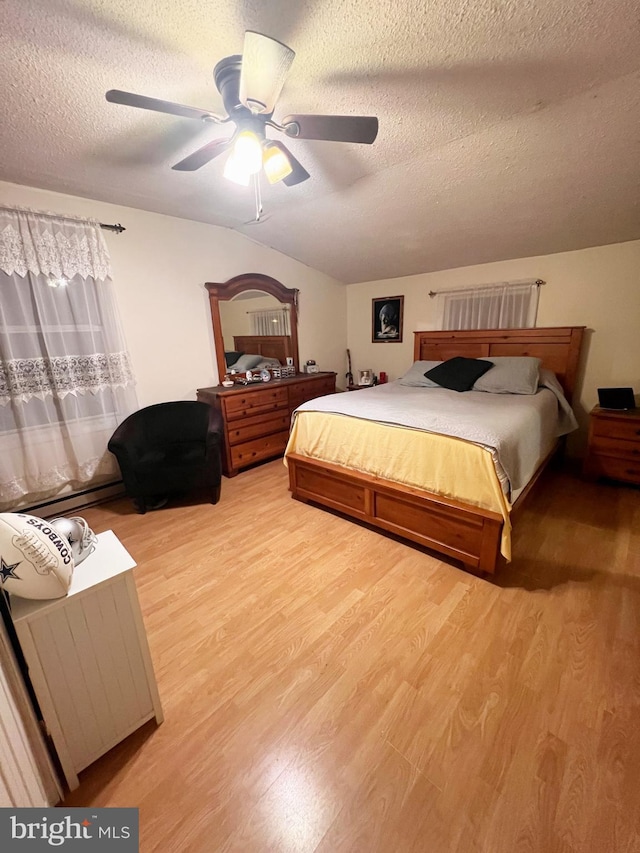 bedroom featuring vaulted ceiling, ceiling fan, a textured ceiling, and wood finished floors