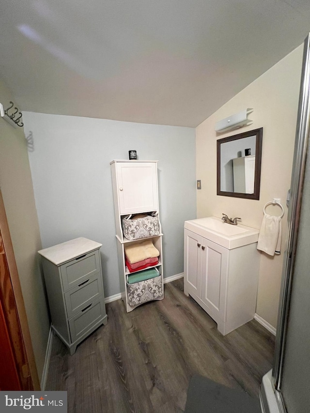 bathroom featuring baseboards, wood finished floors, and vanity