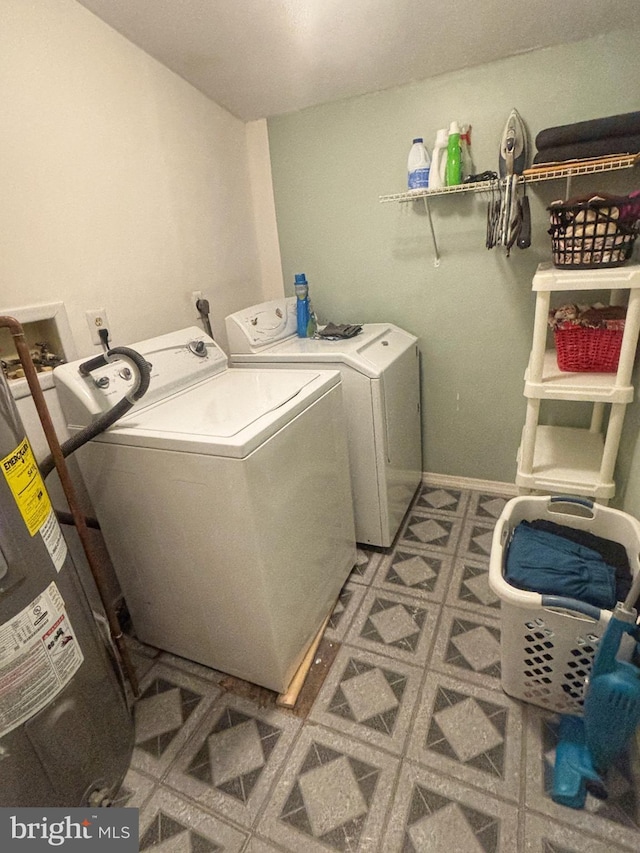 laundry room featuring laundry area, baseboards, washer and clothes dryer, tile patterned floors, and water heater