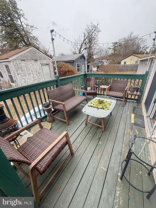 wooden terrace with a storage shed, a residential view, fence, and an outdoor structure