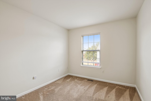 carpeted empty room featuring visible vents and baseboards