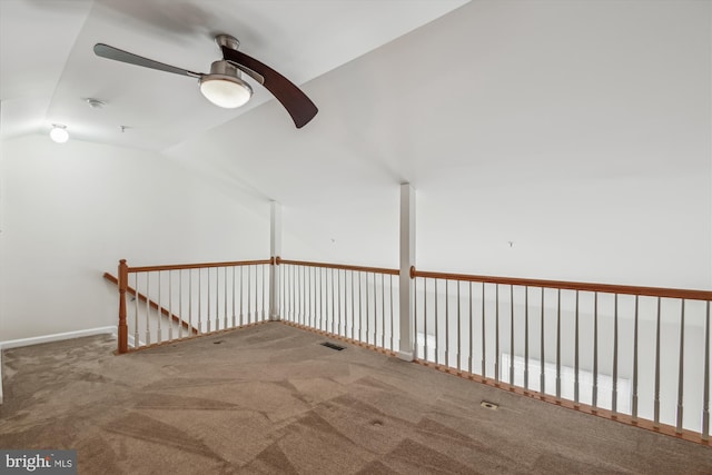 carpeted empty room with a ceiling fan, lofted ceiling, and visible vents