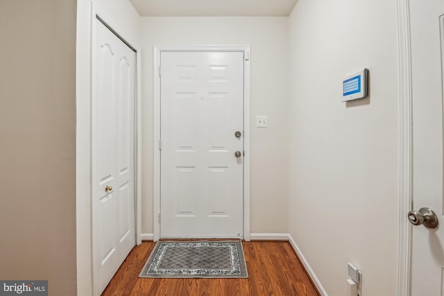 entryway featuring baseboards and wood finished floors