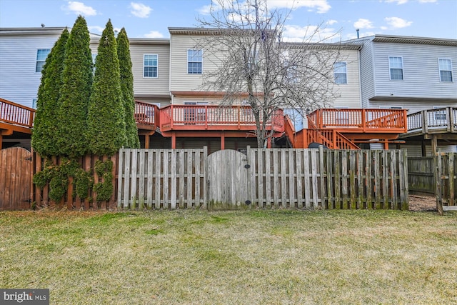 rear view of house featuring a gate, a fenced backyard, a yard, and a deck