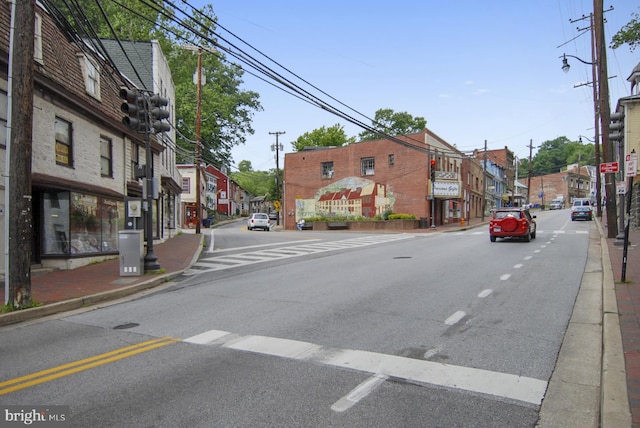 view of road featuring sidewalks, street lighting, and curbs