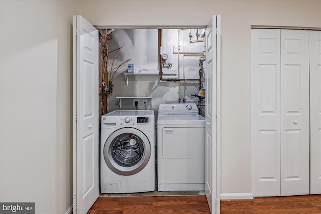 washroom with laundry area, independent washer and dryer, and wood finished floors