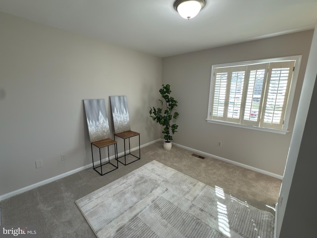 unfurnished room with baseboards, visible vents, and carpet flooring