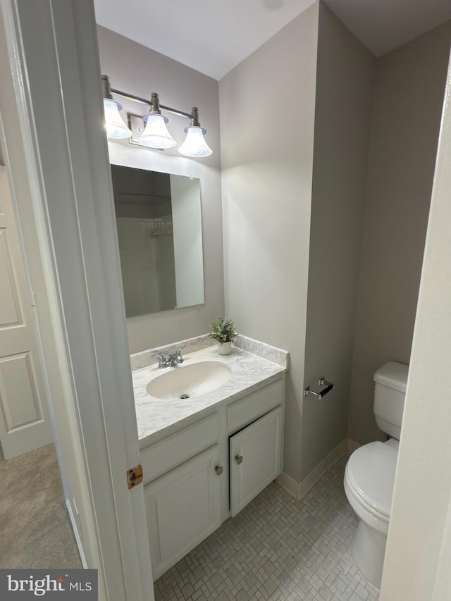 bathroom with toilet, baseboards, and vanity