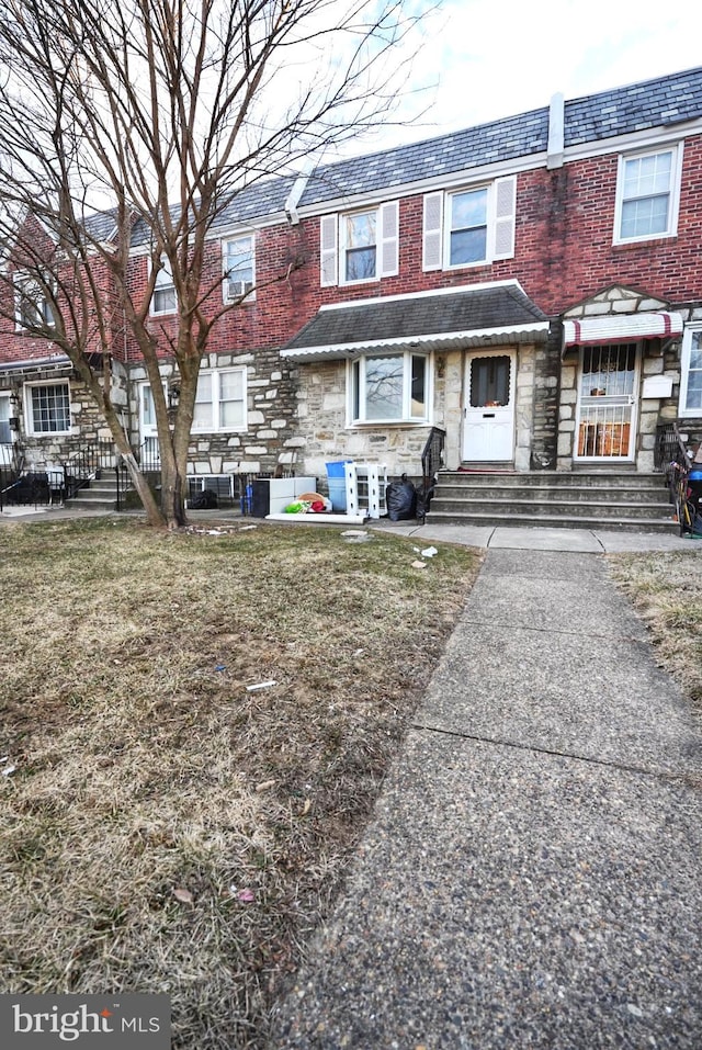 multi unit property featuring entry steps, mansard roof, brick siding, stone siding, and a high end roof