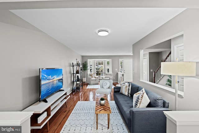 living area with stairway, wood finished floors, baseboards, and french doors