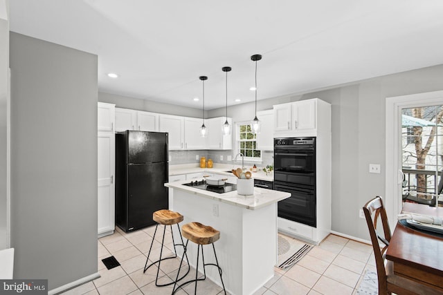 kitchen featuring decorative backsplash, black appliances, white cabinets, and light tile patterned flooring