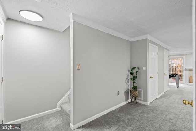 hallway featuring visible vents, baseboards, stairs, carpet floors, and a textured ceiling