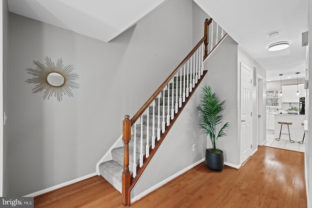 stairs featuring baseboards and wood-type flooring