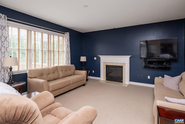 carpeted living room featuring a premium fireplace and baseboards