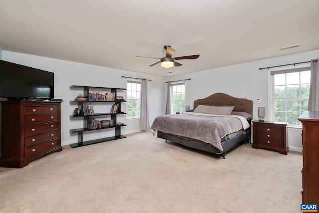 bedroom with baseboards, visible vents, ceiling fan, and light colored carpet